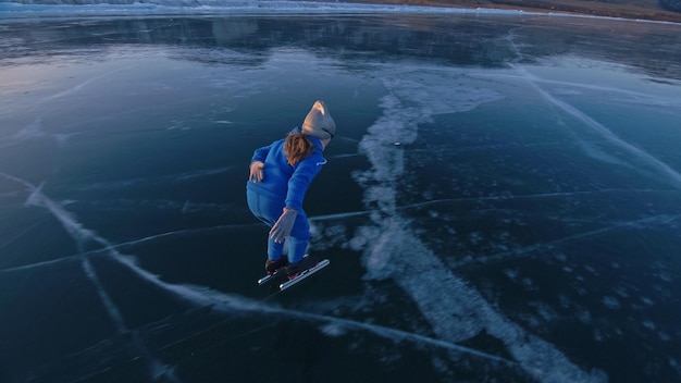 L'enfant s'entraîne sur le patinage de vitesse professionnel sur glace La fille patine en hiver dans des vêtements de sport costume de lunettes de sport Ralenti extérieur