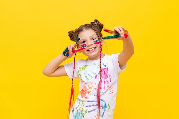 L'enfant s'est sali dans de la peinture multicolore Une petite fille avec des nattes adore peindre Cours de dessin de peinture La créativité des enfants
