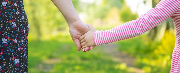 Un enfant avec sa mère passe par la main. Mise au point sélective.