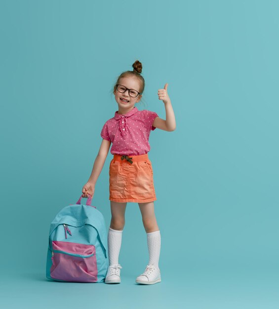 Enfant avec sac à dos sur fond de couleur