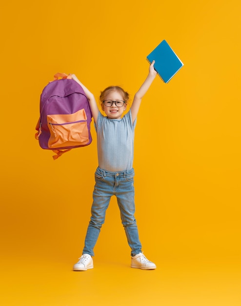 Enfant avec sac à dos sur fond de couleur