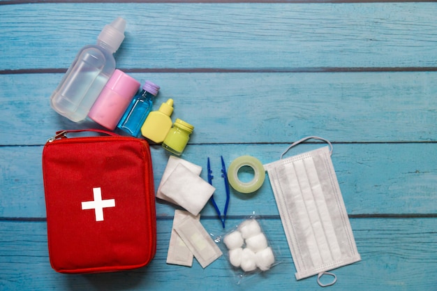 Enfant de sac de premiers soins vue de dessus avec des fournitures médicales sur fond de bois.