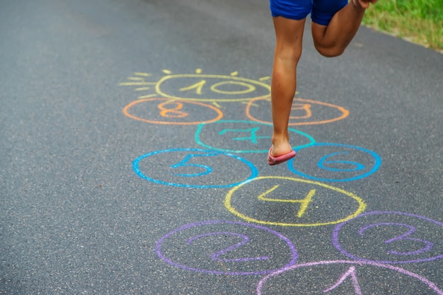 Enfant sautant des classiques sur le trottoir. Mise au point sélective.nature