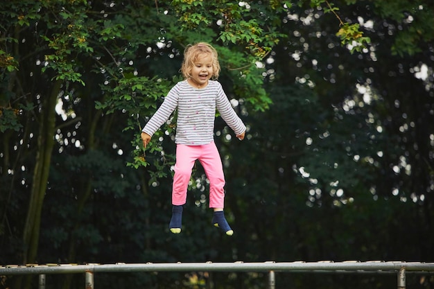 Photo enfant sautant sur un trampoline dans le jardin du soir au danemark