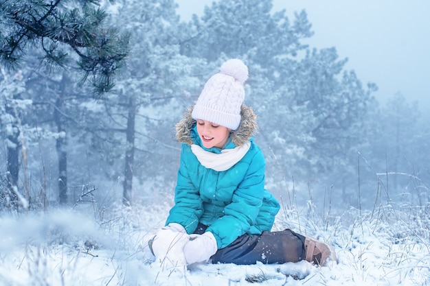 Photo l'enfant sculpte dans la neige. la fille dans la neige. plaisir d'hiver.