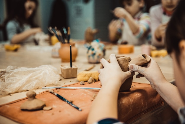 Photo l'enfant sculpte le produit à partir d'argile brute