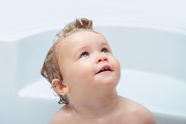 Enfant se baignant mignon petit garçon profitant d'un bain et baigné dans la salle de bain