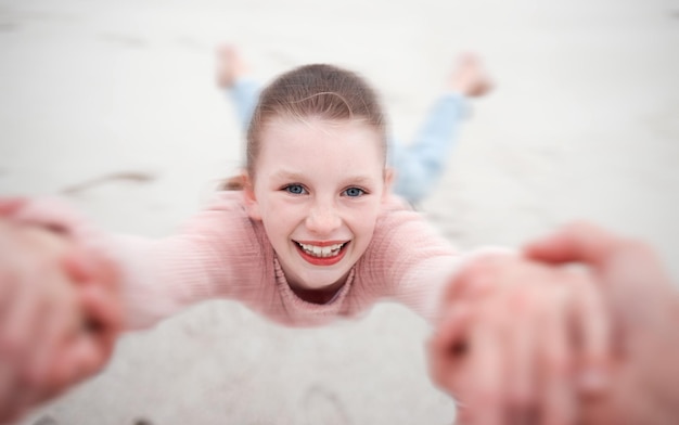 Enfant se balançant des mains à la plage pov et sourire heureux et rire Mouvement amusant ou fille dans le jardin tournant à partir du soutien des bras de papa dans la nature Enfant sable et balançoire de la main dans le champ en Suède