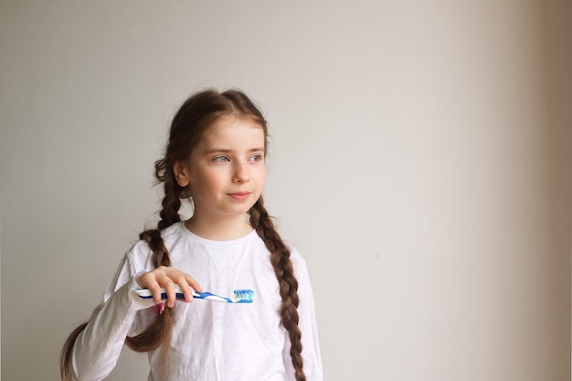 l'enfant se brosse les dents fille avec une brosse à dents pour écrire