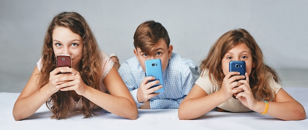 Un enfant se cache derrière les téléphones