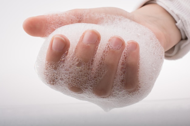 Un enfant se lave les mains avec de la mousse