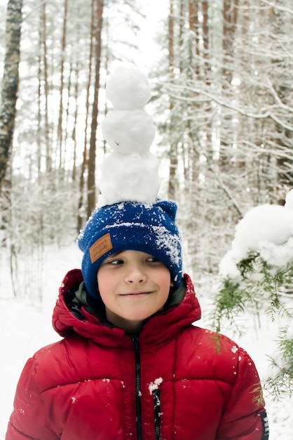 Un enfant se promène dans une forêt enneigée. Promenade d'hiver.