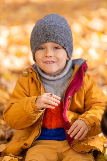 Un enfant se réjouit de jouer avec une coccinelle dans un parc en automne. Enfance heureuse.