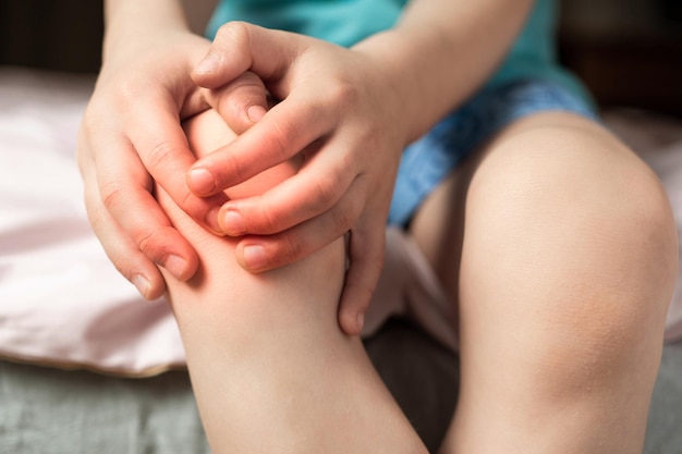 L'enfant se tient à un genou douloureux