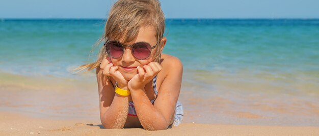 L'enfant se trouve dans le sable sur la plage.