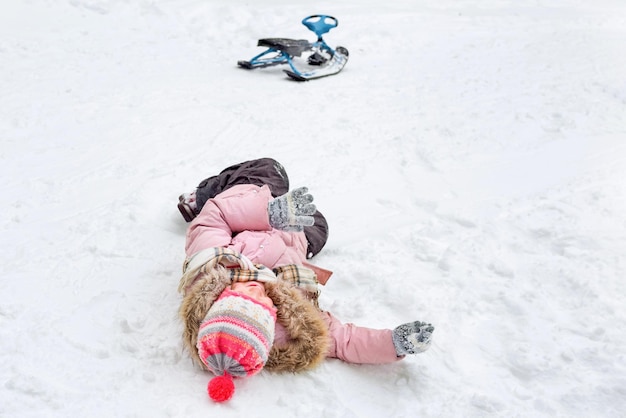 L'enfant se trouve sur la neige en hiver