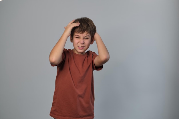 L'enfant semble accablé les mains tirant sur les cheveux reflète l'importance de nourrir les compétences d'adaptation