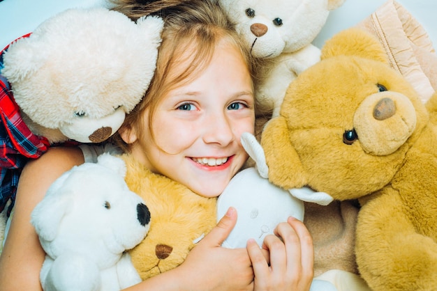 Enfant serrant l'ours en peluche kid drôle de visage près de jouets jouets dream kid fille rêves près de tiys teddy childho