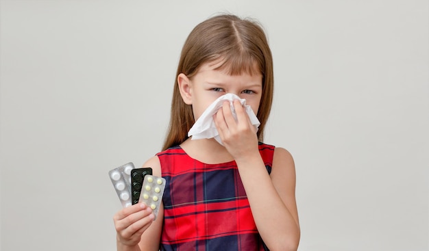 Enfant avec une serviette sur le nez à cause d'une allergie médicamenteuse sur fond blanc