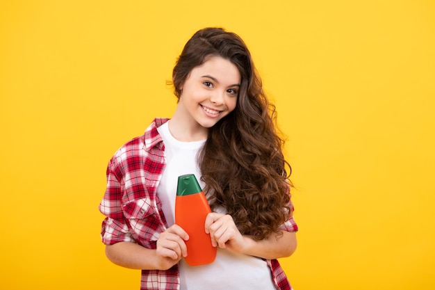 Enfant avec shampooing revitalisant Soins cosmétiques quotidiens Adolescent tenir une bouteille de soins des cheveux et de la peau Beauté