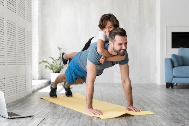 Enfant et son père faisant du sport à la maison