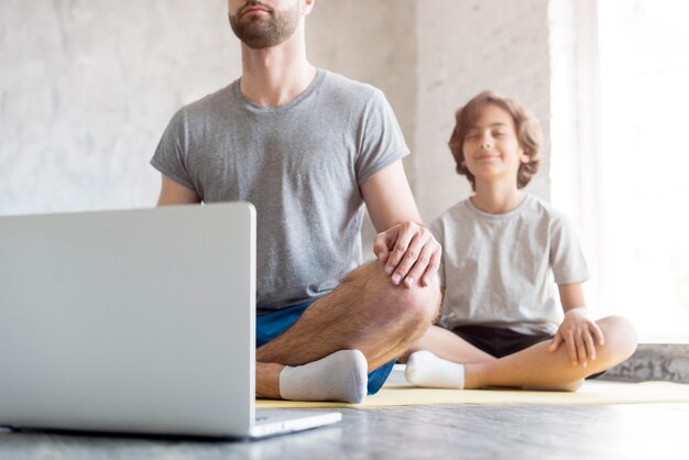 Photo enfant et son père faisant du sport à la maison