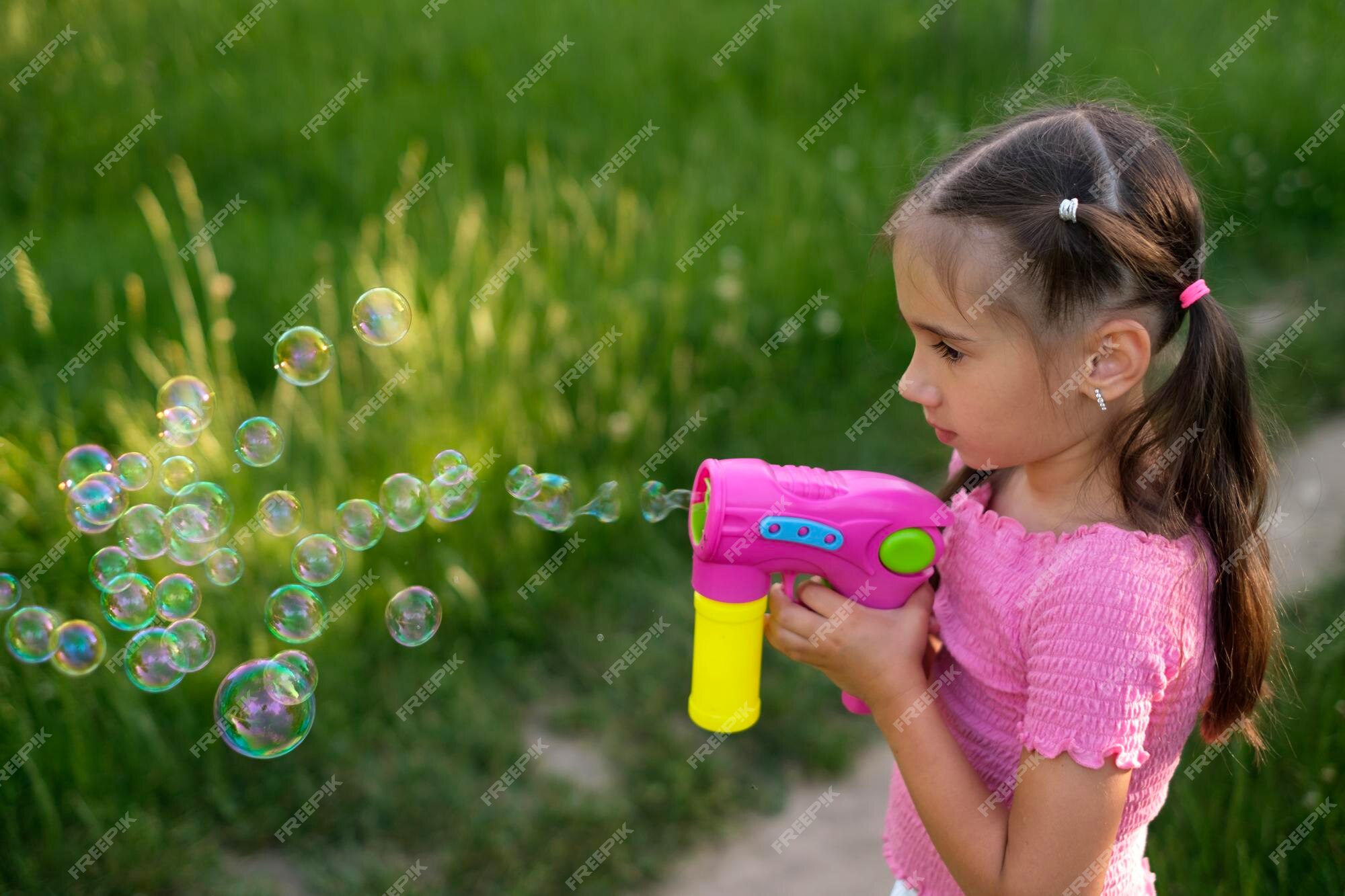 Un Enfant Souffle Des Bulles De Savon Avec Une Arme à Feu