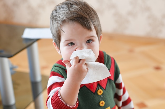 Enfant souffrant de nez qui coule ou d'éternuements. Petit garçon allergique