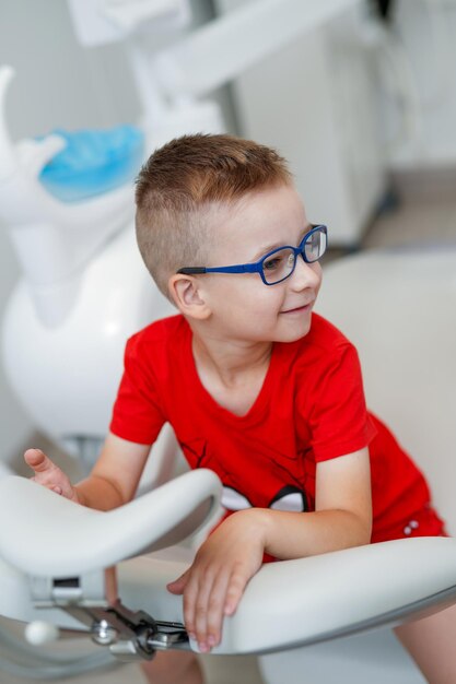 Enfant souriant jouant avec l'équipement du dentiste. Petit garçon médecin dentiste.