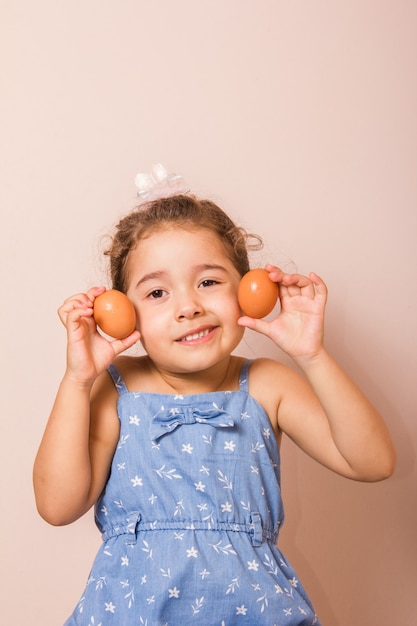 Enfant souriant tenant deux oeufs