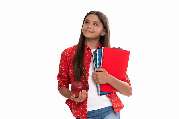 Un enfant souriant tient un cahier d'école pour étudier et un déjeuner aux pommes isolé sur l'éducation blanche