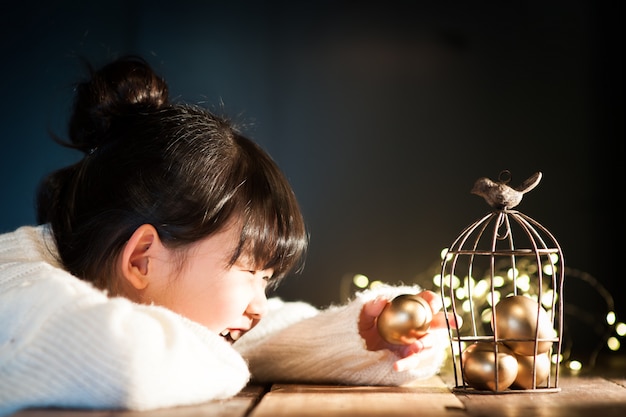 L'enfant souriant tient un œuf de Pâques.