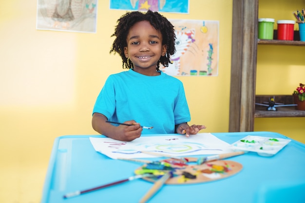 Photo enfant souriant en train de créer une image