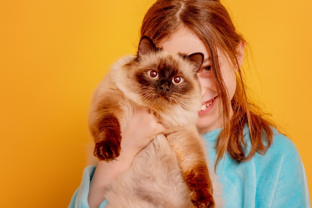 L'enfant sourit avec l'animal Une adolescente avec un chat pointu