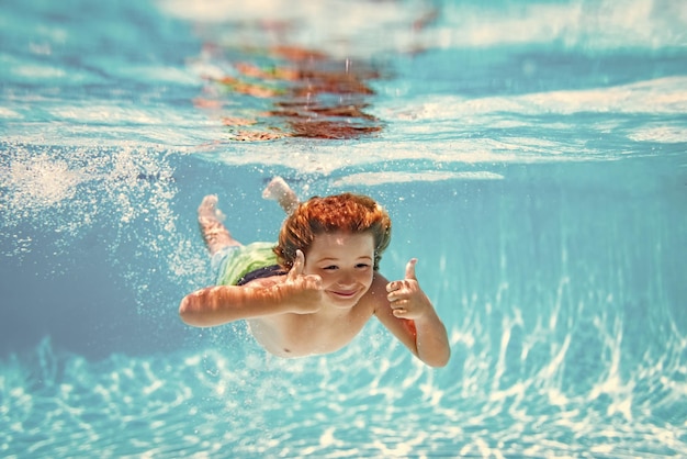 Un enfant sous l'eau nage dans la piscine un enfant en bonne santé nage et s'amuse sous l'eau