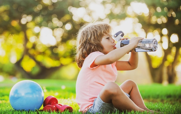 Enfant sport garçon eau potable sport concept enfant fitness santé et énergie exercices en plein air