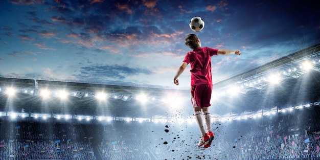 Enfant sur un stade de football. Technique mixte