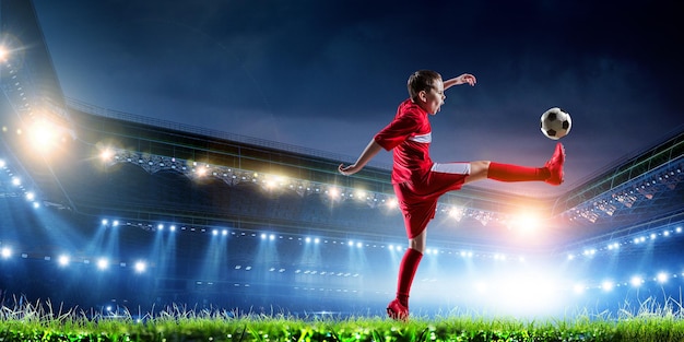 Enfant sur un stade de football. Technique mixte