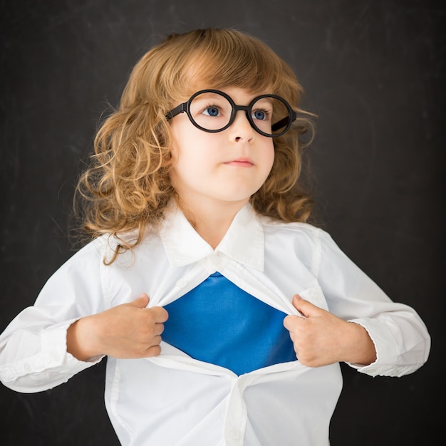 Enfant de super-héros en classe. Kid contre tableau noir. Notion d'éducation