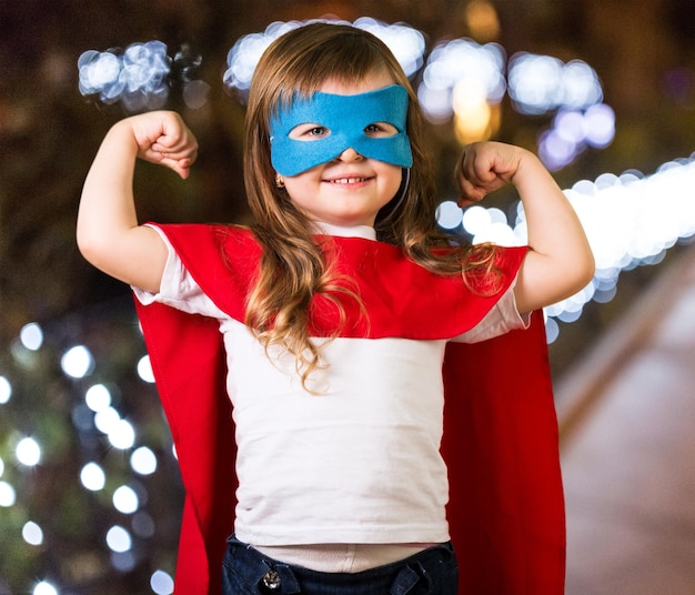 Un enfant super-héros portant des gants de boxe sur un fond de ciel bleu Concept de pouvoir féminin et féministe