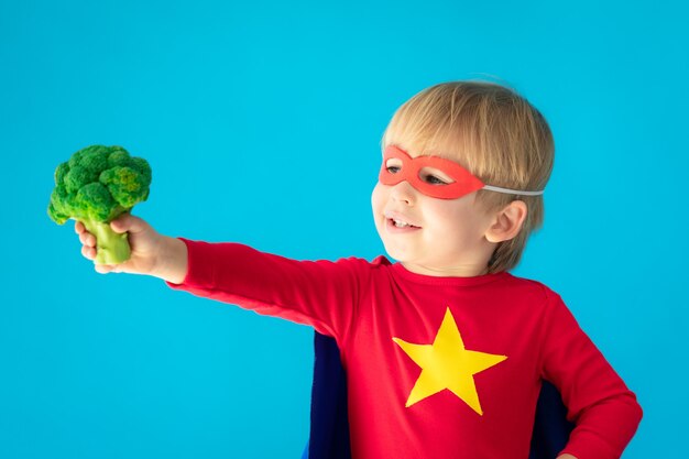 Enfant de super-héros tenant le brocoli