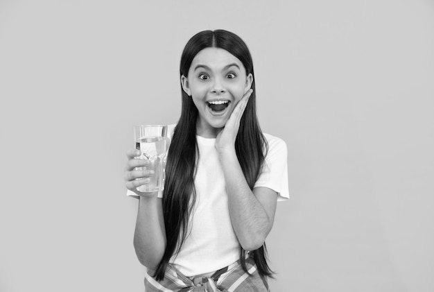 Un enfant surpris boit de l'eau pour rester hydraté et maintenir l'équilibre quotidien de l'eau dans la santé du corps