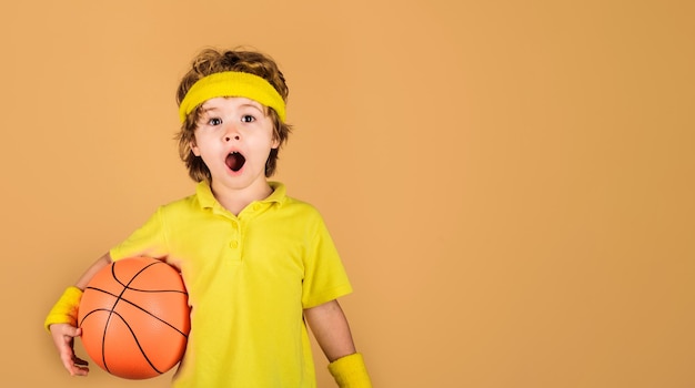 Enfant surpris avec un équipement de sport de ballon de basket-ball garçon sportif avec un sport professionnel de basket-ball