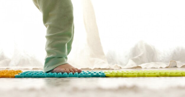 Enfant sur un tapis de massage faisant des exercices de prévention des pieds plats