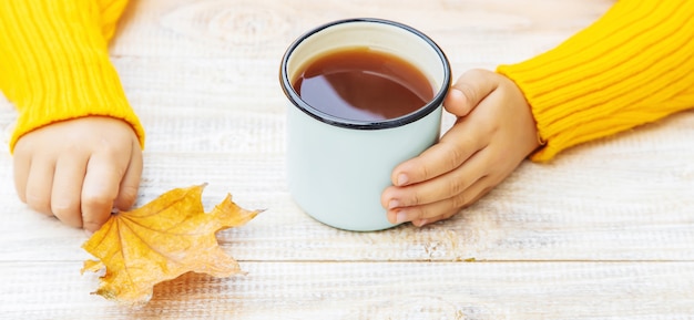 Enfant avec une tasse de thé dans les mains