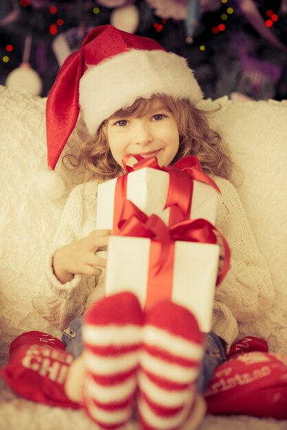 Enfant tenant un cadeau de Noël. Concept de vacances de Noël