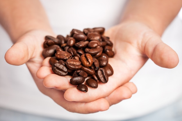 Enfant tenant des grains de café dans les mains