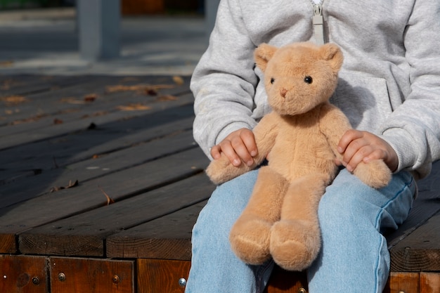 Photo un enfant tenant un ours en peluche à l'extérieur