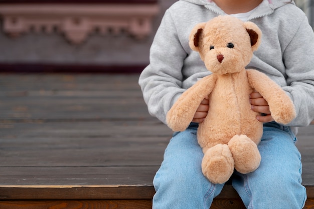 Photo un enfant tenant un ours en peluche à l'extérieur