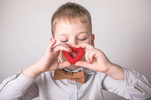 Enfant tenant un petit coeur rouge